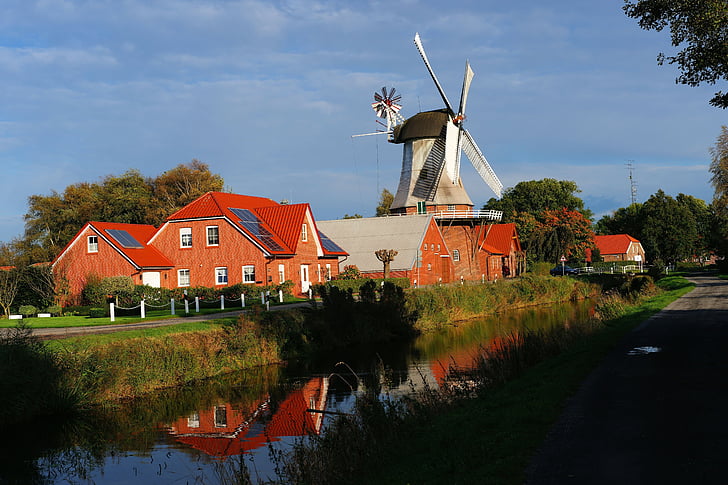 windmill beside river surrounded by trees
