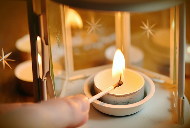 photo of white scented candle on gray steel candle holder