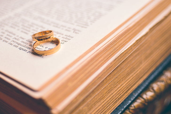 two gold-colored rings on open book