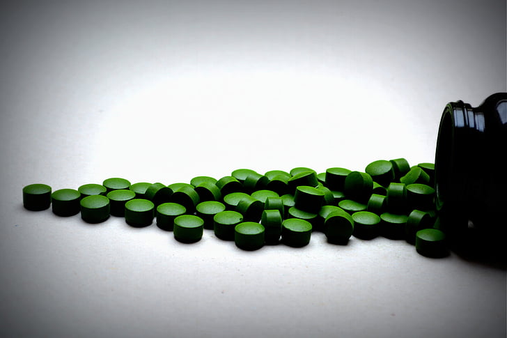 photography of green supplement pills