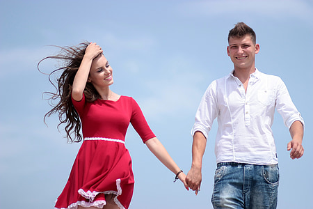 smiling woman holding hands with smiling man