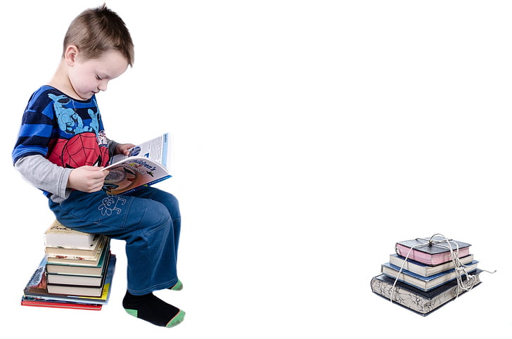 boy in blue long-sleeved shirt reading a book