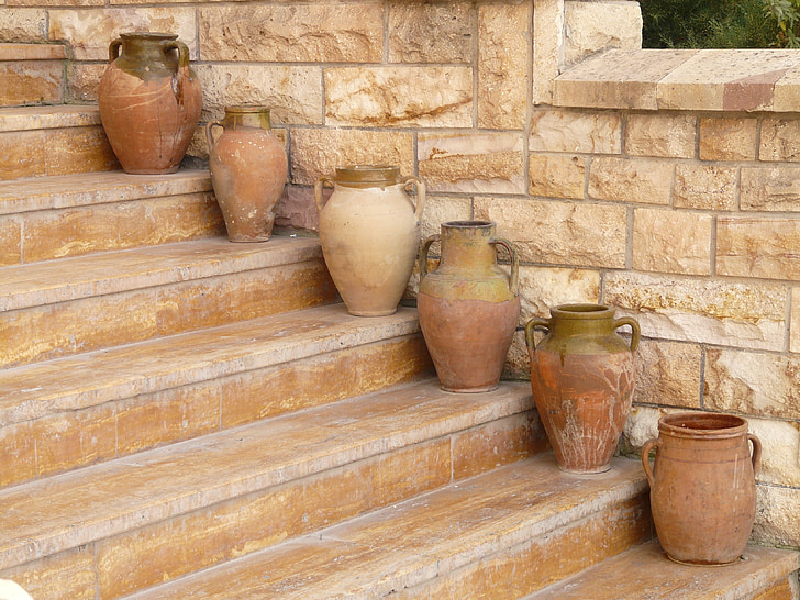 six brown clay pots on stairs