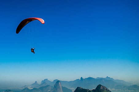 person riding on parachute near mountains