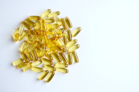 gold pills on white surface