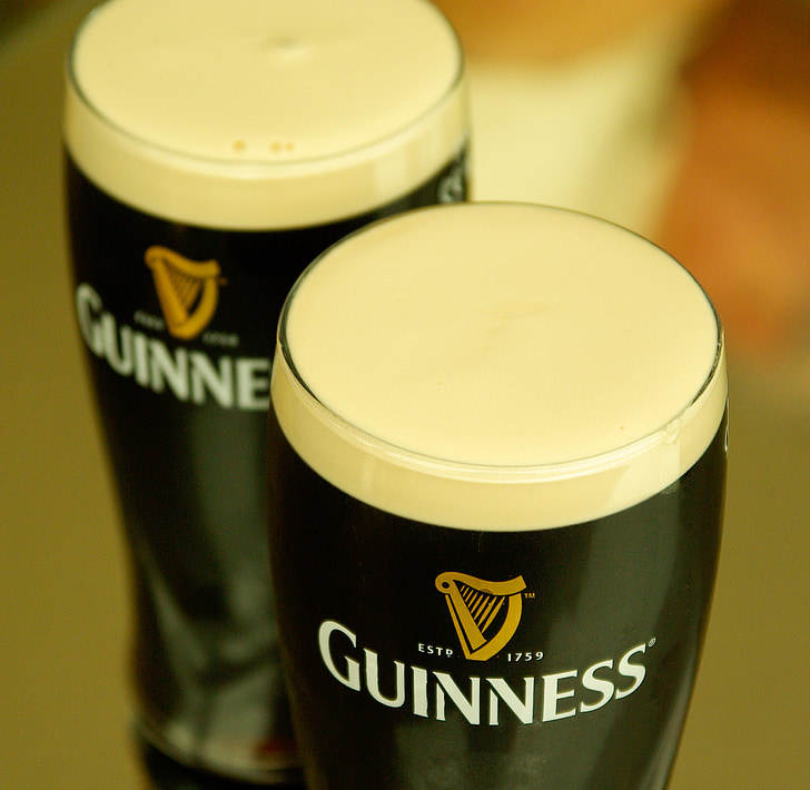 closeup photography of two Guinness pilsner glasses