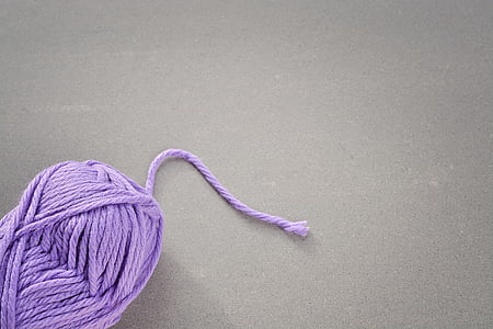 rolled purple yarn on gray surface