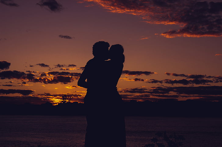 silhouette of man and woman kissing each other