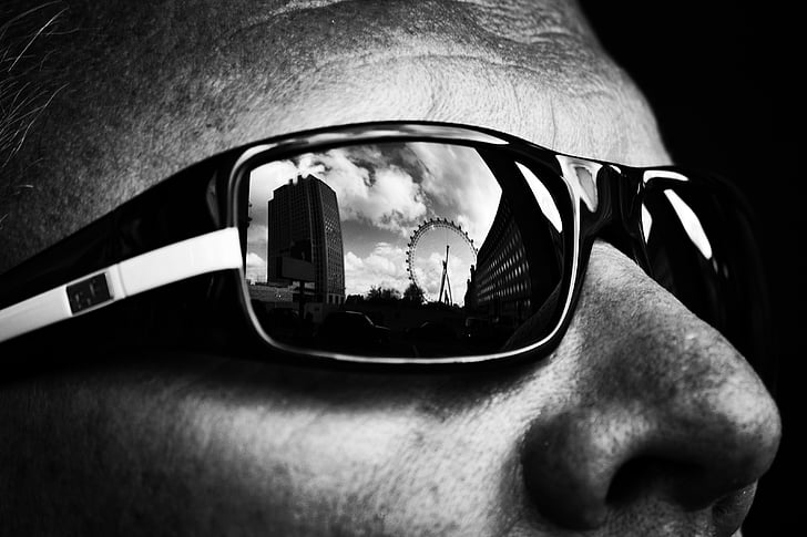 ferris wheel reflection on man's sunglasses