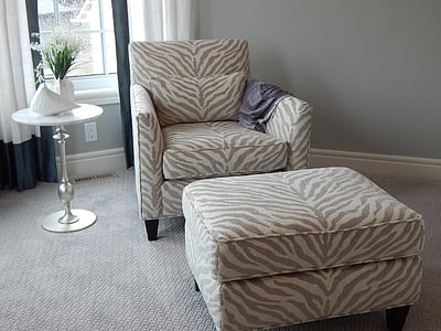 gray and beige zebra skin printed sofa chair with ottoman beside side table