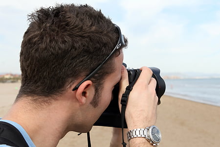 man taking a photo at the beach using DSLR camera