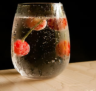 four red cherries on clear liquid