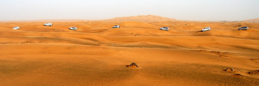 white and silver vehicle running on sand at daytime