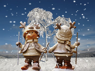 two snowman holding hands near white tree under blue sky during daytime