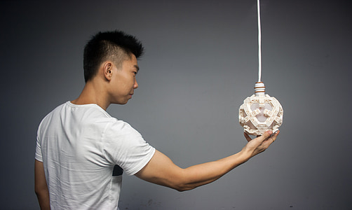 person holding beige stone pendant lamp
