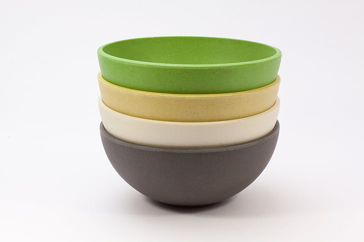 four green, brown, beige, and gray bowls on white surface
