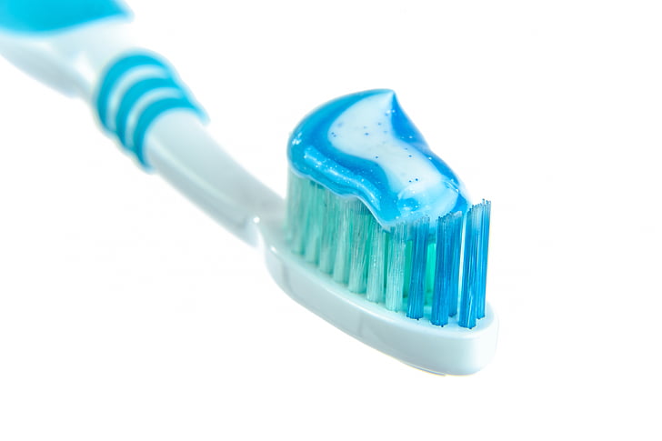 white and blue toothbrush with white and blue toothpaste