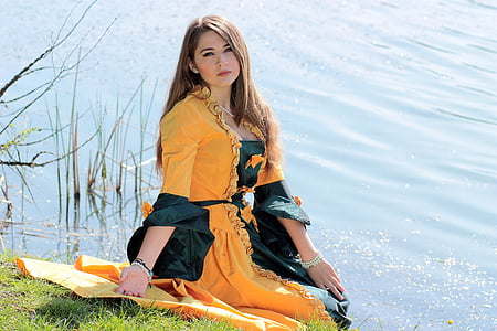 woman in yellow dress sitting on green grass