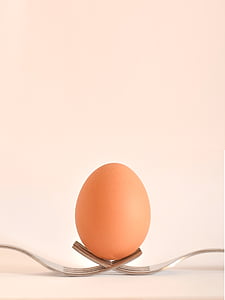 brown egg on two silver forks