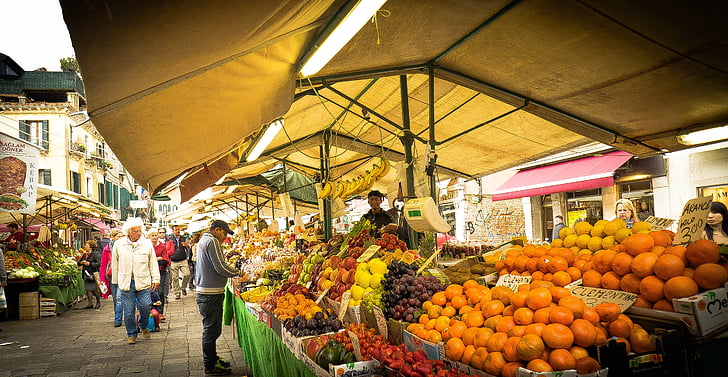 man wearing gray jacket and pants buying on fruit market