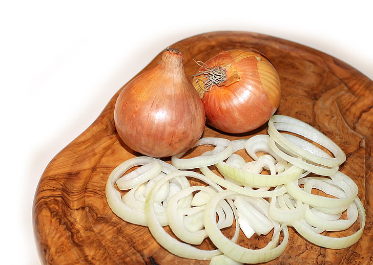 close-up photo of white onion bulbs on chopping boar