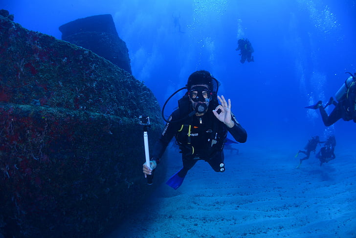 underwater photography of person wearing diving attire