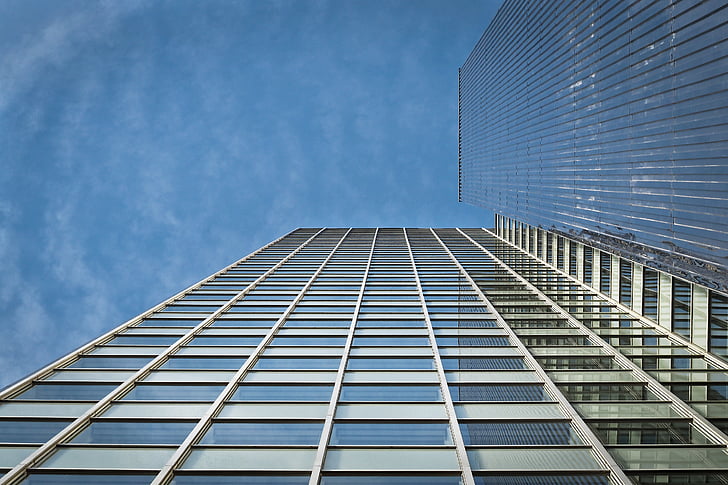 low angle photo of glass high rise building under clear blue sky