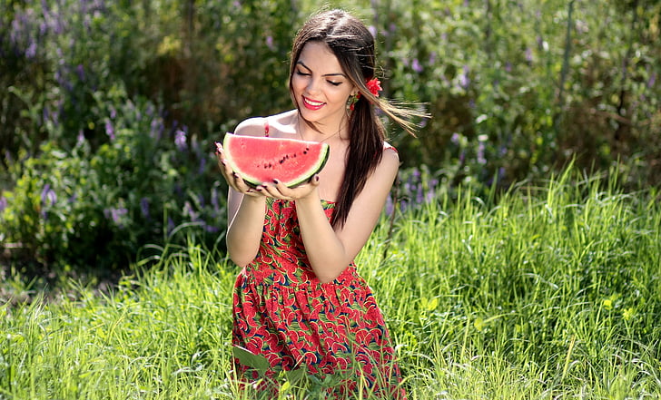 woman in red floral dress holding watermelon fruit