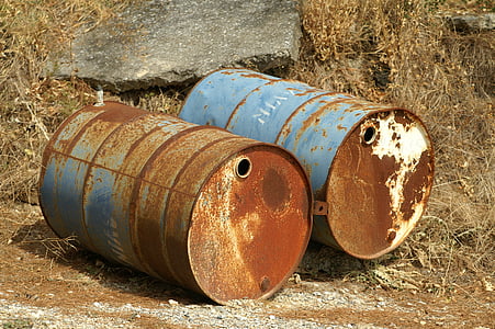 two blue-and-brown metal drums on brown surface