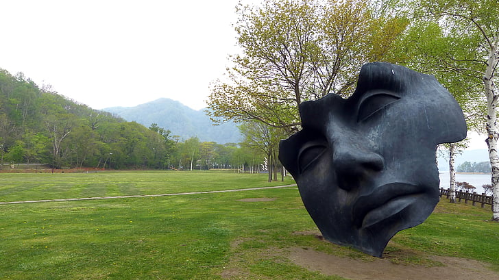 face statue near body of water during daytime