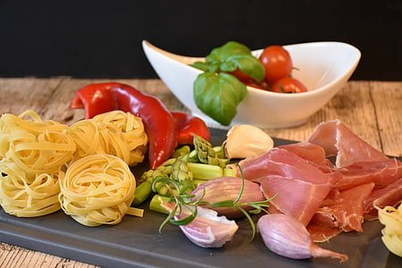 pasta, bell pepper and raw meat on chopping board