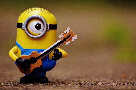 shallow focus photography of Stuart The Minion playing guitar display figure