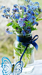 blue cluster flowers on clear glass jar