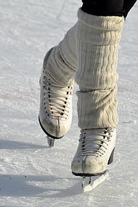 person in white ice skating shoes on ice rink