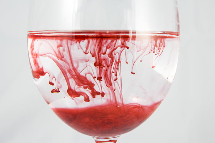 red liquid in clear drinking glass