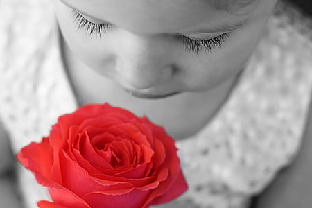 selective color photo of girl smelling rose
