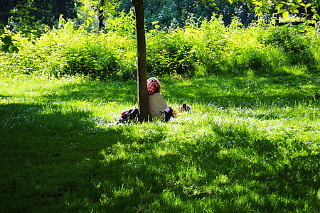 woman leaning on tree trunk