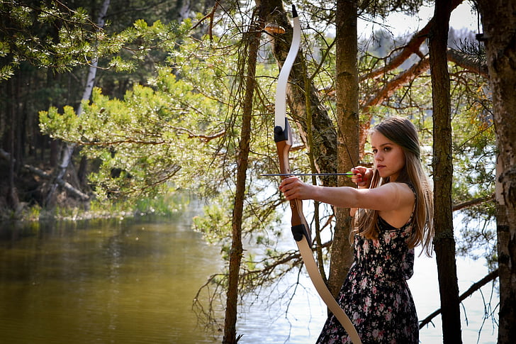 woman holding brown composite bow