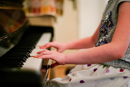 person playing brown and white piano