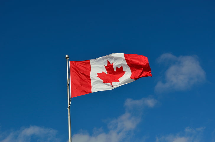 Canada flag under the blue sky during daytime
