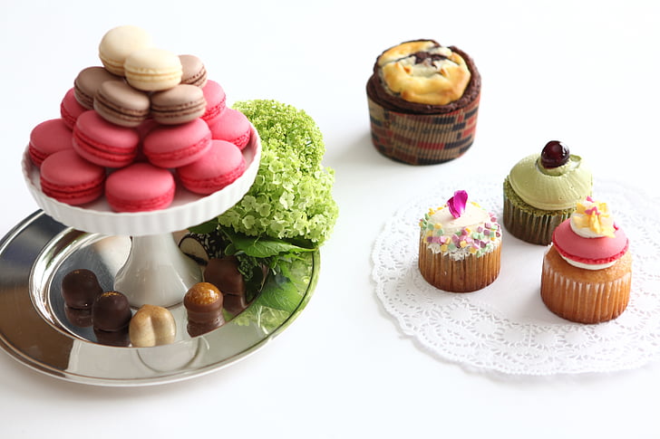 cupcakes on plate and stand above white surface