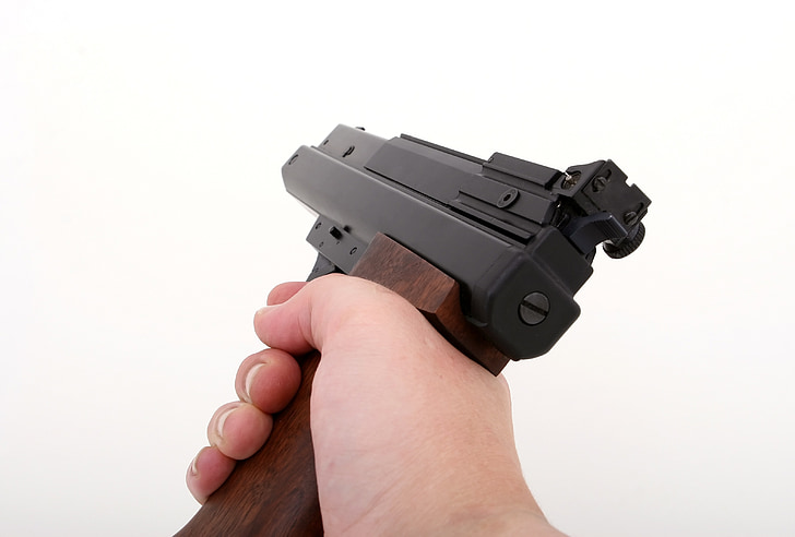 person's hand holding semi-automatic pistol