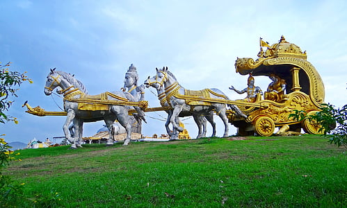 statue of people on wagon pulled by horses