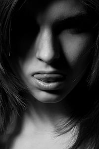 grayscale photo of woman showing her tongue