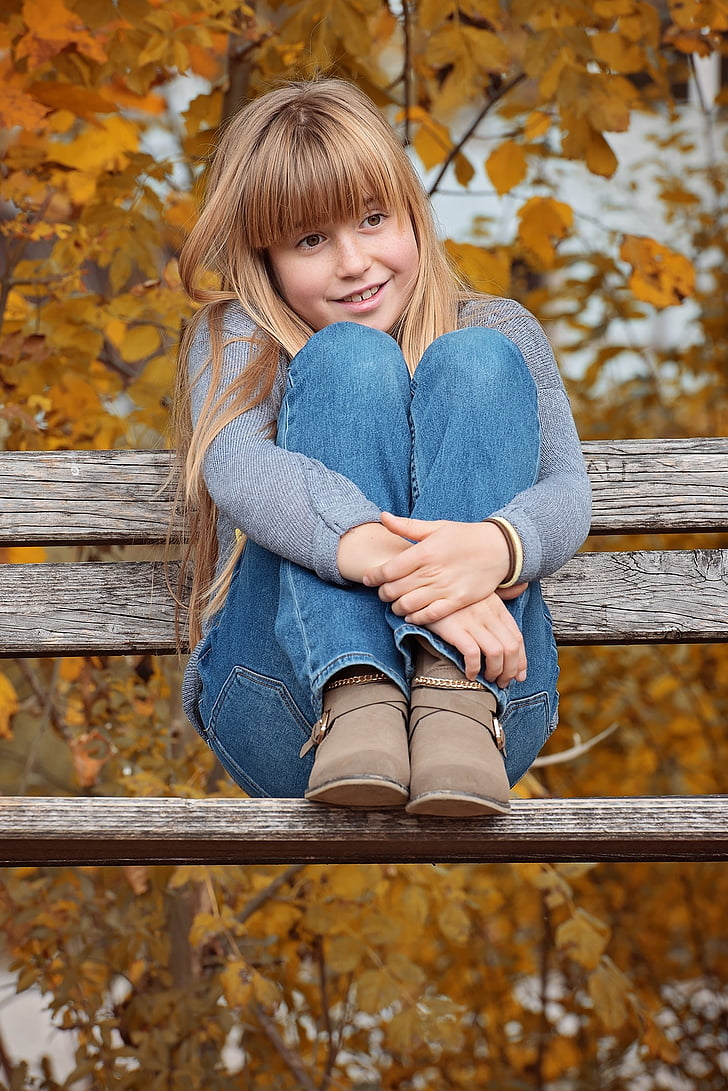 girl sitting on brown bench