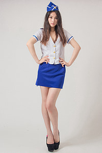 woman wearing button-up shirt and mini skirt with cap and hands on waist