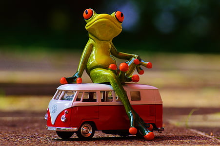 green frog toy sitting on a red Volkswagen T2 van toy