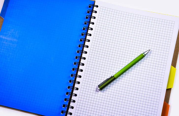 white graphing notebook and green click pen