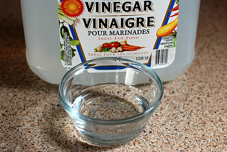 clear glass bowl beside vinegar bottle