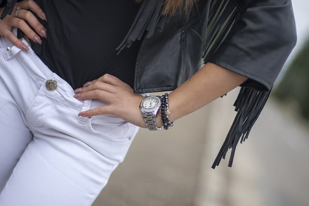 woman wearing fringed black leather jacket and white pants